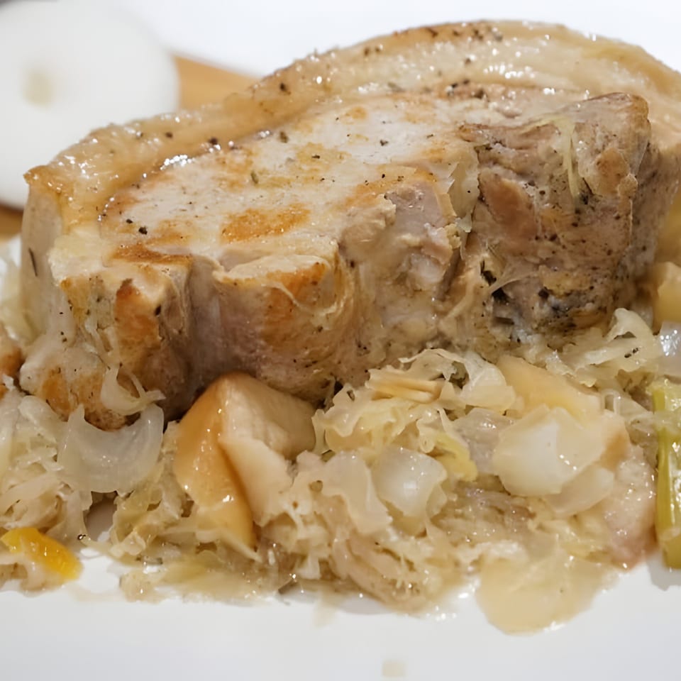 Close-up of Polish pork chop with sauerkraut and mushrooms on a white plate.